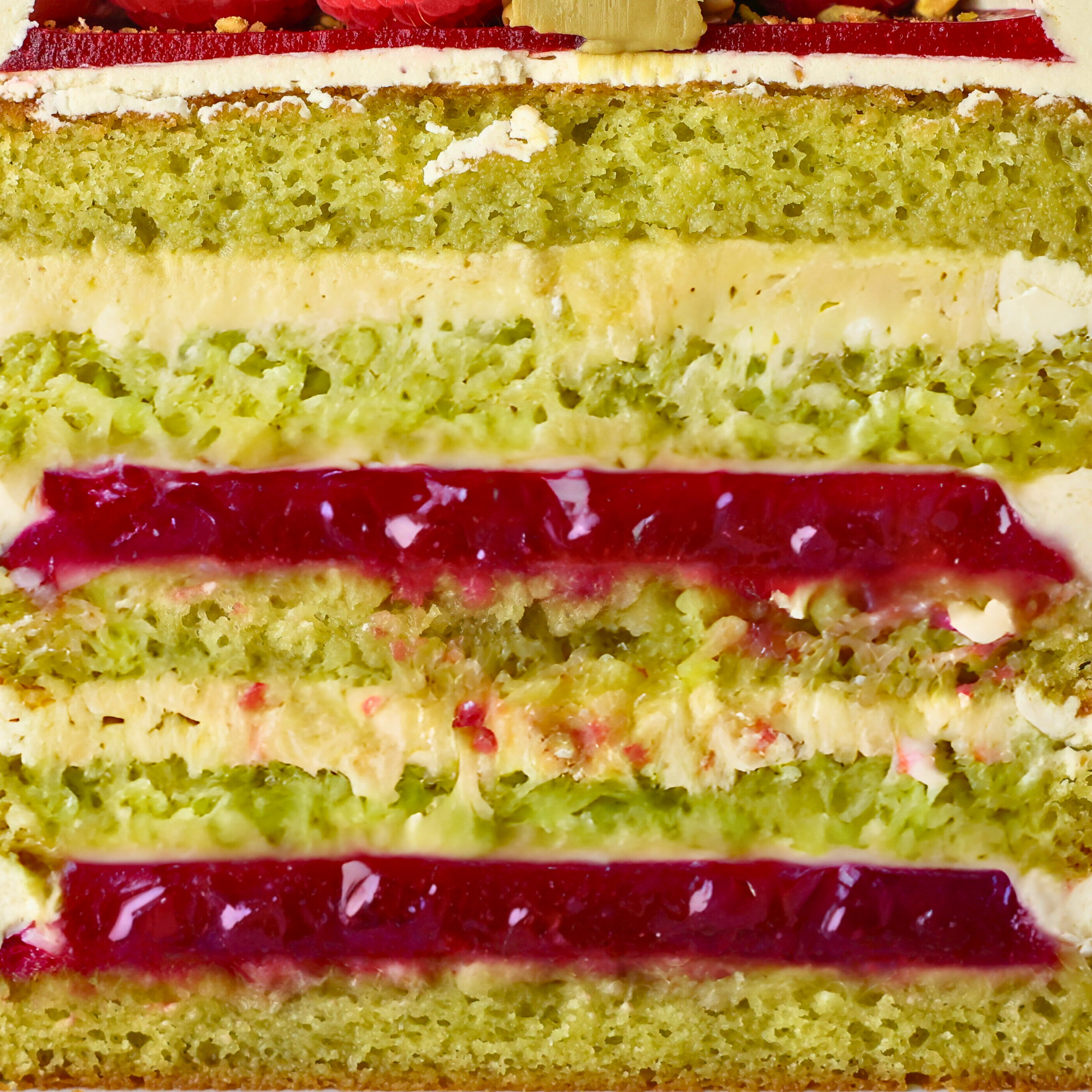 Close-up of a layered cake with green layers and red jelly filling